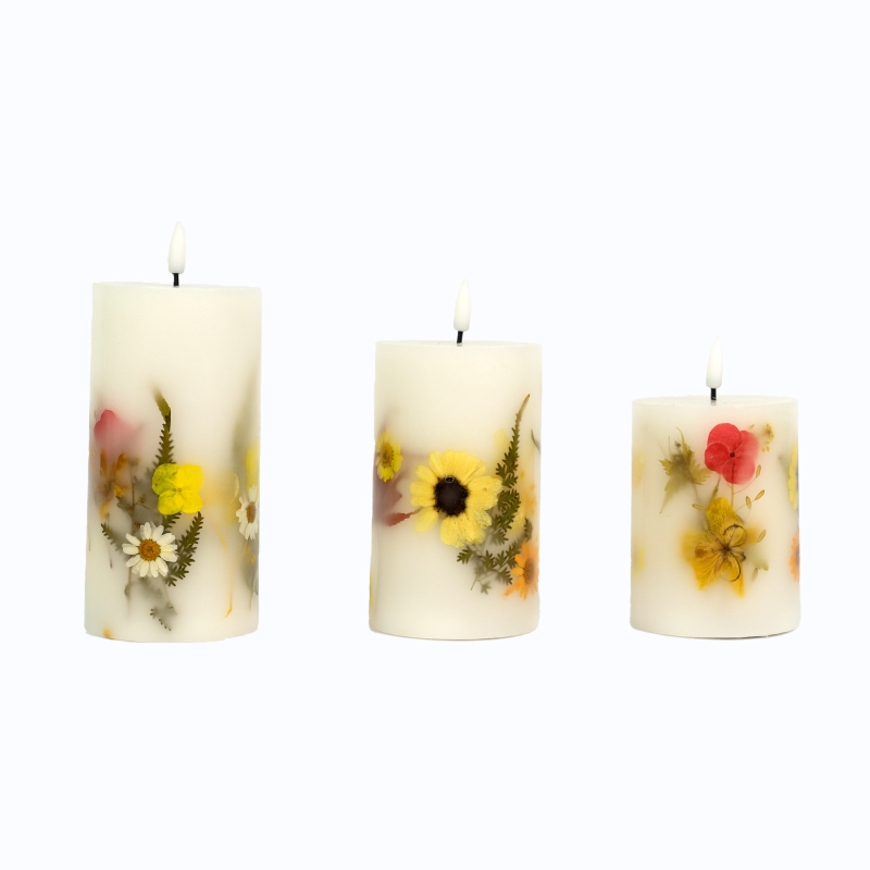 Three ivory BESTER LED pillar candles with yellow, red and white botanical decorations